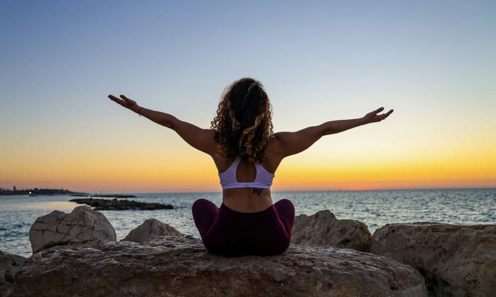 Woman meditating at the coast